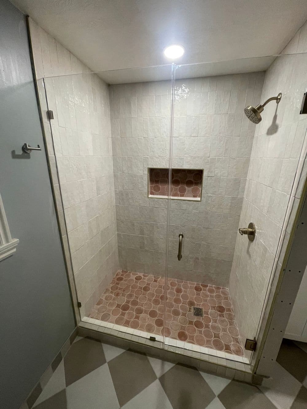 Modern glass shower enclosure with tile accents and built-in niche. Clean and spacious design.
